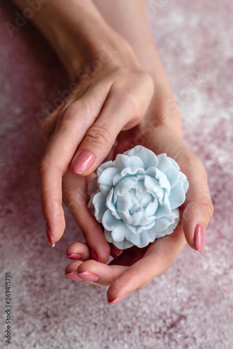 Beautiful blue flower made of soap in delicate female hands