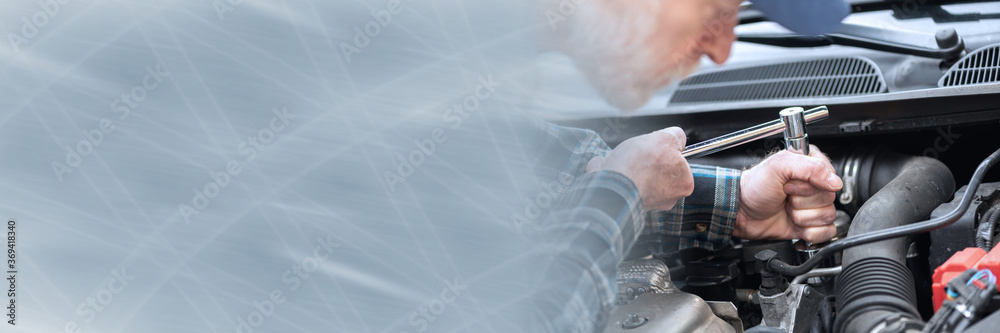 Car mechanic working on car engine; panoramic banner Car mechanic working on car engine; panoramic banner