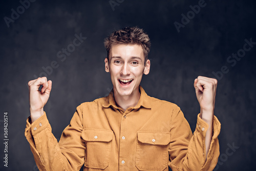 young man with success gesture on dark background