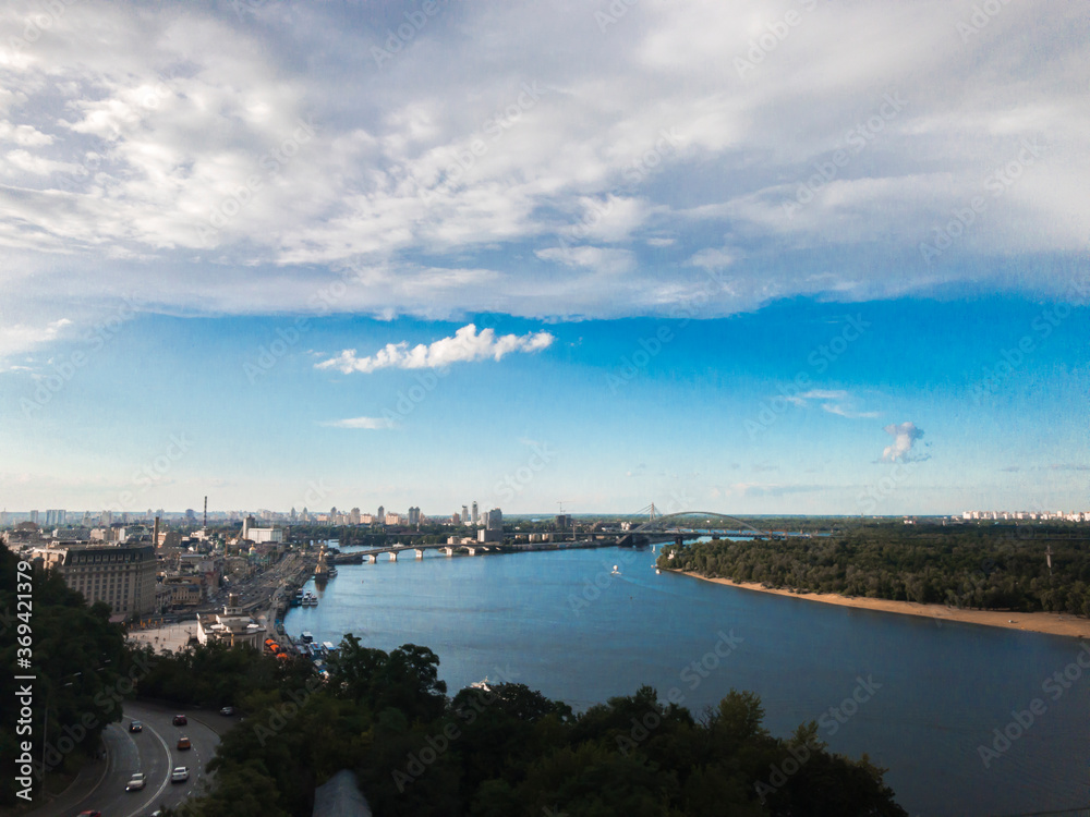 Panoramic view of Dnipro river and side of Kyiv from the point view. Blue sky, green grass and urban landscape of Kyiv, Ukraine.