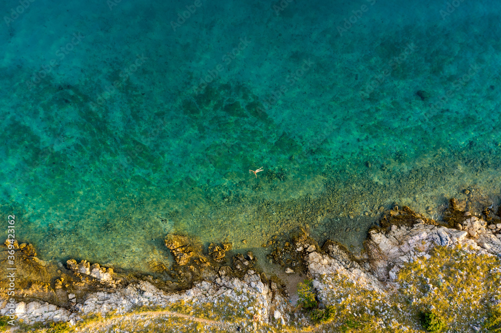Obraz premium Aerial view of a naked girl swimming in sea