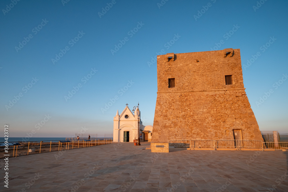 Torre di Nao and church of the Madonna di Capo Colonna at sunset on the Ionian Sea. Capo Rizzuto, Crotone, Calabria, Italy.