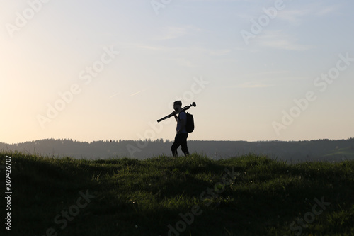 silhouette of a photographer carrying tripod