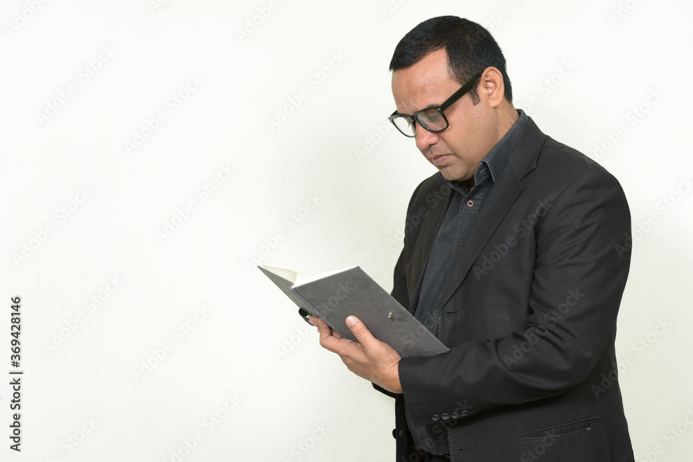 Portrait of Indian businessman in suit with book Portrait of Indian businessman in suit with book