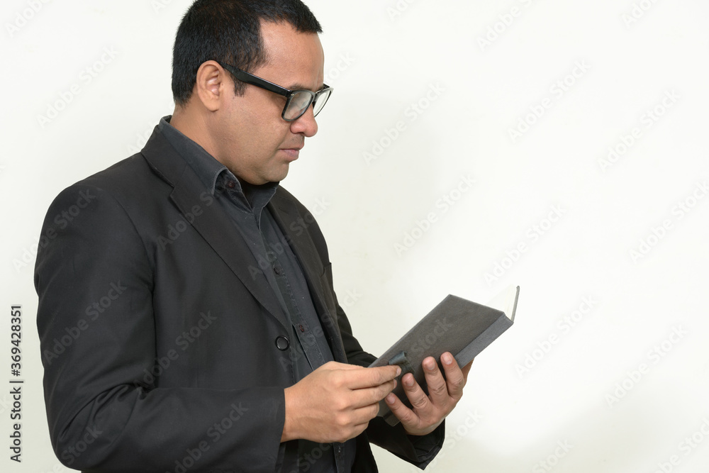 Portrait of Indian businessman in suit with book Portrait of Indian businessman in suit with book