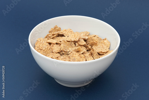 Bowl of whole grain muesli isolated on the blue background.