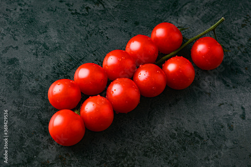 red tomatoes with water droplets on a dark background photo