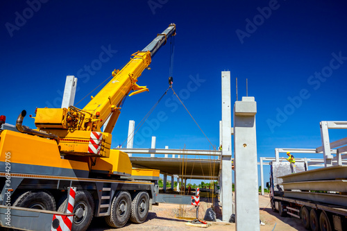 Foto Mobile crane is carry concrete joist to assembly huge hall