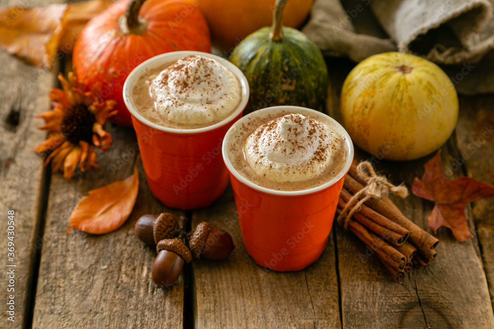 Pumpkin spiced latte in orange glasses on wood background, copy space Pumpkin spiced latte in orange glasses on wood background, copy space
