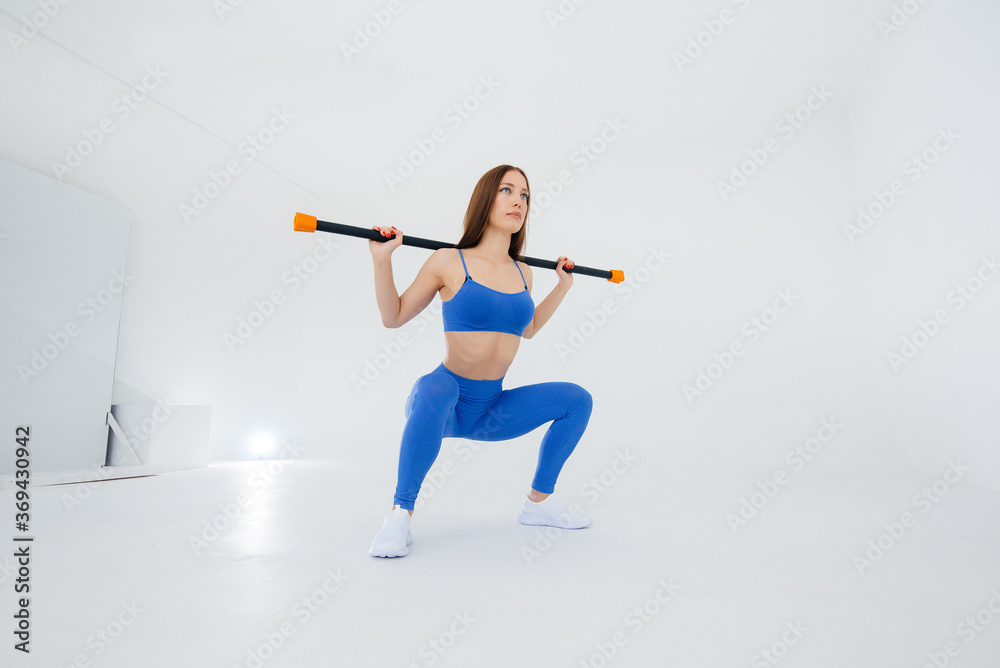 Sexy young girl performs sports exercises on a white background. Fitness, healthy lifestyle Sexy young girl performs sports exercises on a white background. Fitness, healthy lifestyle
