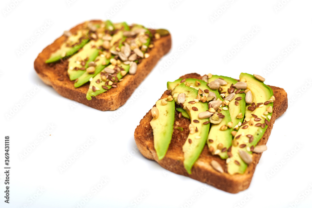Toast with avocado slices, a mixture of seeds on a white background. Healthy snack tomorrow. The concept of proper nutrition, diet.