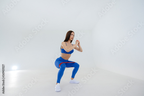 Sexy young girl performs sports exercises on a white background. Fitness  healthy lifestyle