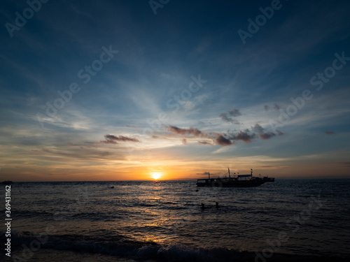 Stunning sunrise over the beach in Philippines. Diving boats waiting for early morning divers. © Beata