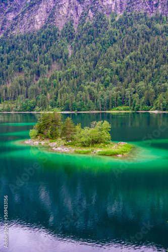 Fototapeta Naklejka Na Ścianę i Meble -  Small islands with pine-trees in the middle of Eibsee lake with Zugspitze mountain. Beautiful landscape scenery with paradise beach and clear blue water in German Alps, Bavaria, Germany, Europe.