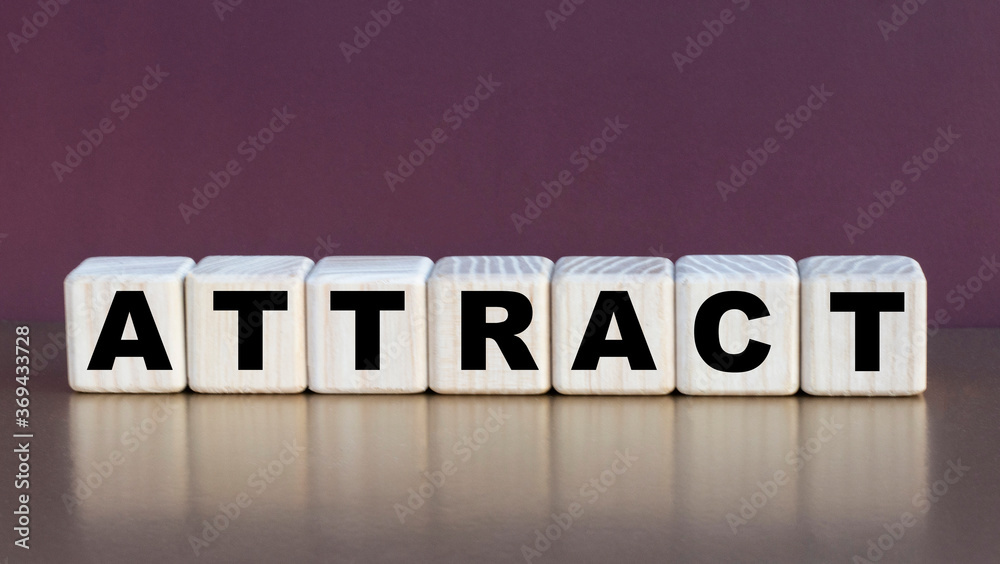 Obraz premium ATTRACT - the word on the cubes on a beautiful burgundy background