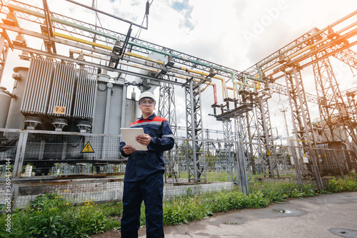 The energy engineer inspects the equipment of the substation. Power engineering. Industry © Andrii