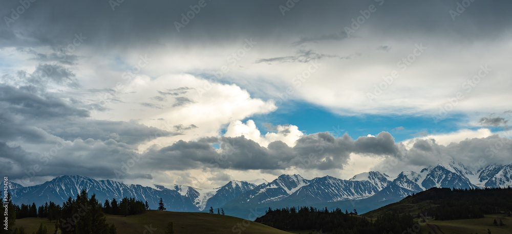 View of the snow-capped mountains with clouds before a thunderstorm