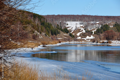 Panorama of spring ice melting on the Sylva River near the Ice Mountain in the vicinity of the city of Kungur, Perm Territory. Spring in the foothills of the Western Urals.