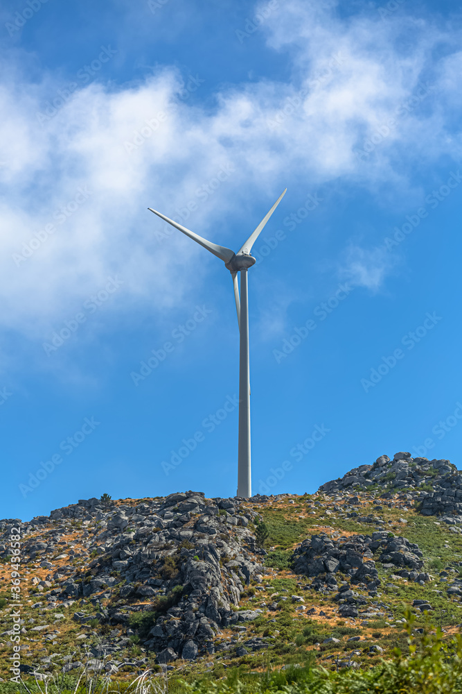 View of a wind turbine on top of mountains View of a wind turbine on top of mountains