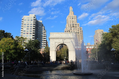 Washington Square Arch and fountain on a sunny day with blue sky in New York City