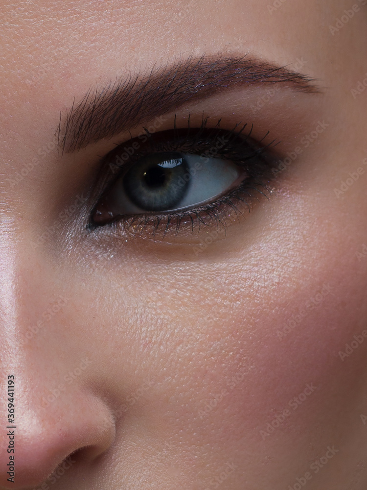 Obraz premium Closeup female eyes with bright make-up, great shapes brows, extreme long eyelashes. Celebrate makeup, luxury eyeshadows. Macro of beautiful eye. Good vision