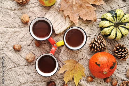 Fototapeta Naklejka Na Ścianę i Meble -  Autumn background.  Autumn leaves,cups, and pumpkin on wooden background.