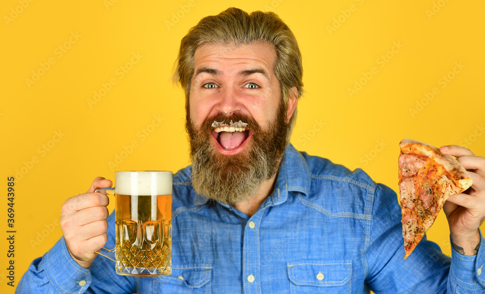 fast food. happy bearded man with beer and pizza. italian food. italy is here. guy in bar drinking beer and eating pizza. Cheers. glass of beer and pizza. watching football on TV fast food. happy bearded man with beer and pizza. italian food. italy is here. guy in bar drinking beer and eating pizza. Cheers. glass of beer and pizza. watching football on TV