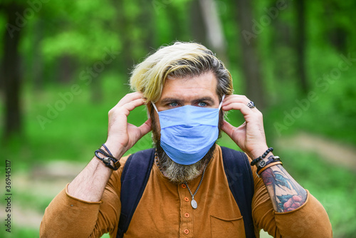 Hipster protecting from air contamination or coronavirus. Virus infection. Man enjoy nature wearing face mask. Stop infection. Slowly emerge from lockdown restrictions. Walk in park. Avoid infection