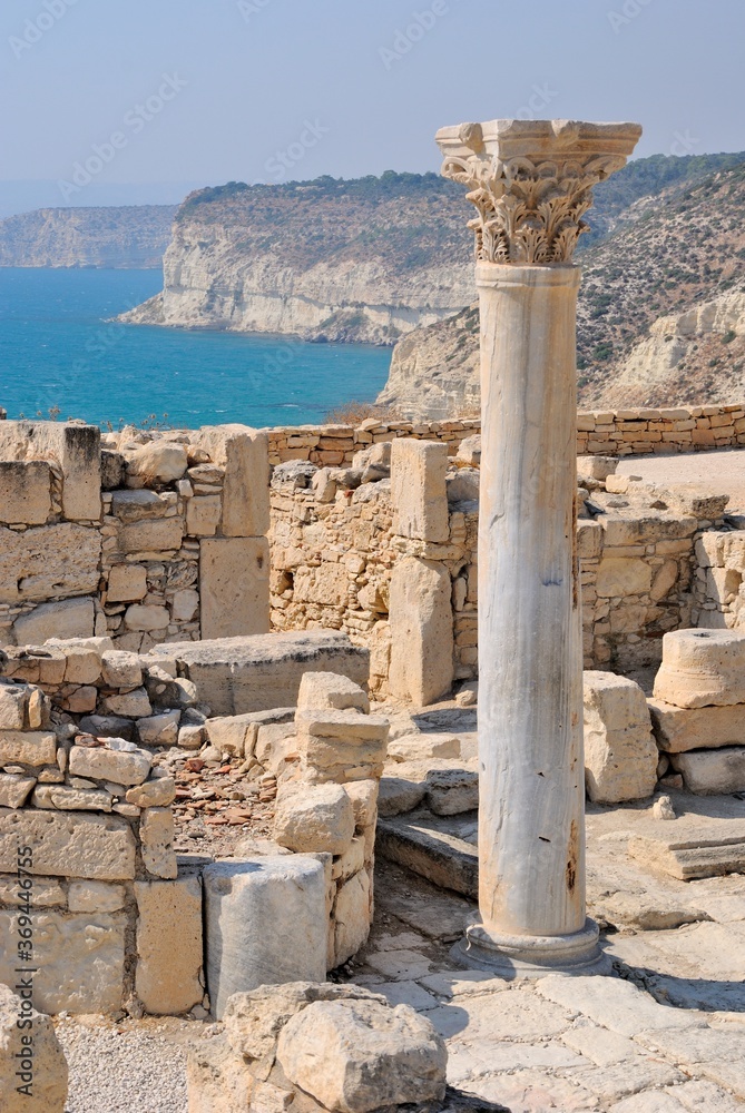 Ruins of the Episcopal Basilica and a well preserved carved column with blue waters of Mediterranean Sea at the background at the Neolithic period Kourion Ancient city in Cyprus 