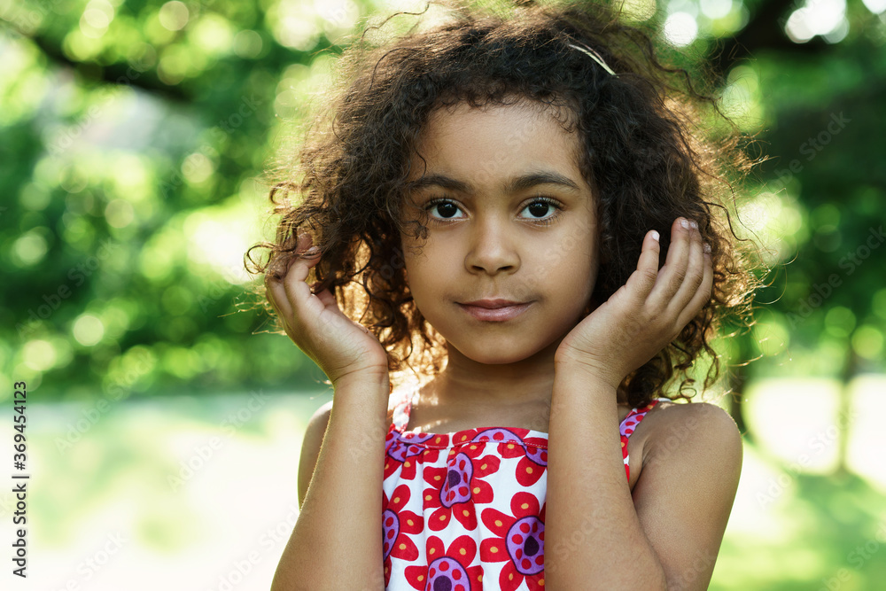 Portrait of cute black girl in a city park