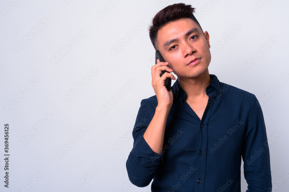 Portrait of young Asian businessman talking on the phone Portrait of young Asian businessman talking on the phone