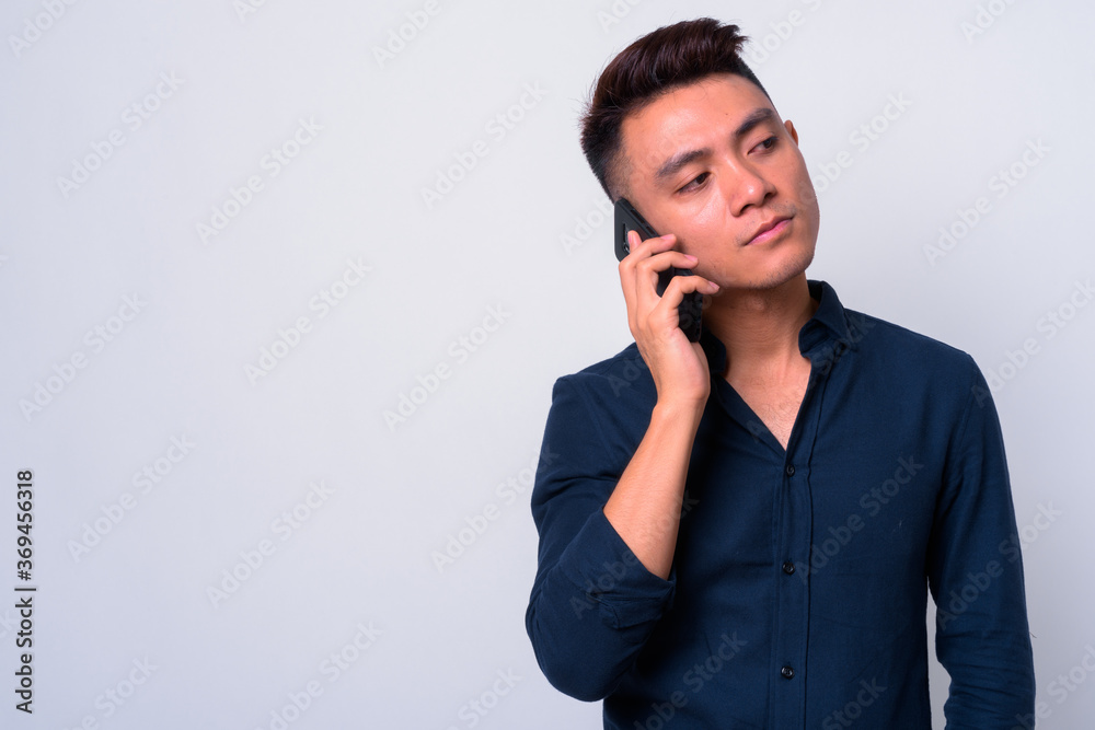 Portrait of young Asian businessman talking on the phone Portrait of young Asian businessman talking on the phone