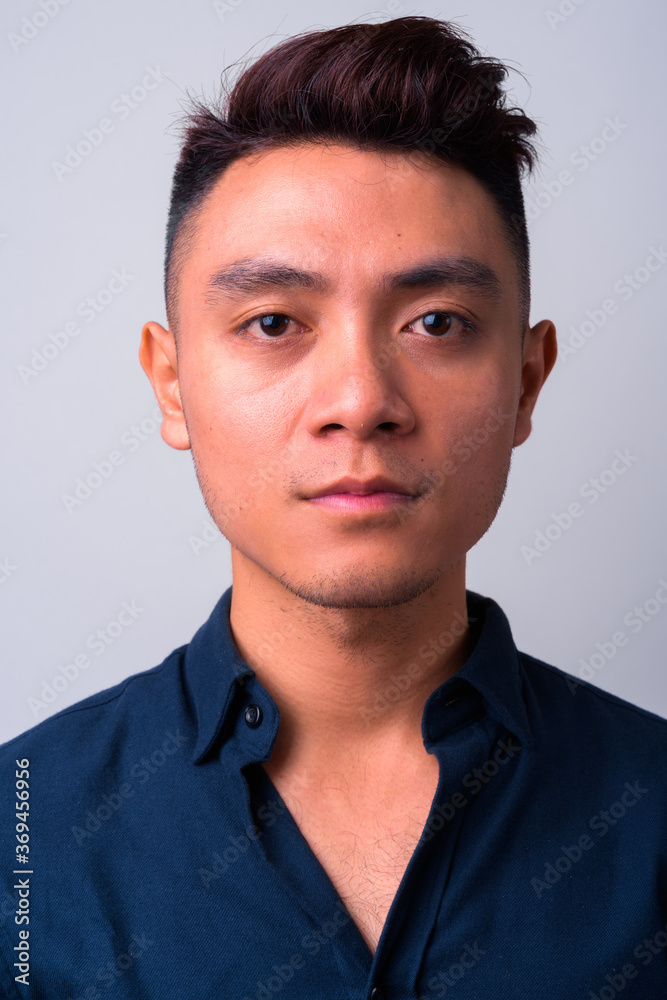 Face of young Asian businessman looking at camera Face of young Asian businessman looking at camera