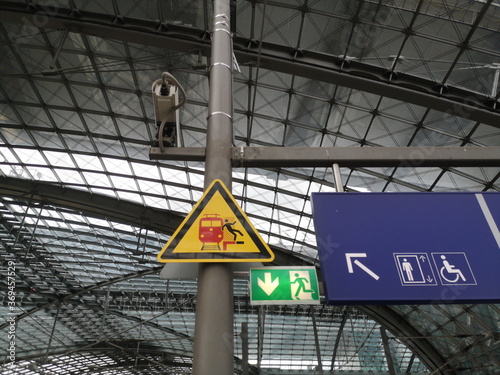 Dreieckiges Schild mit Warnung vor einfahrenden Zügen im Hauptbahnhof der Hauptstadt Berlin
