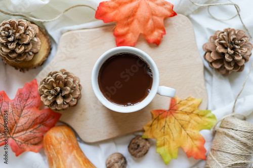 Autumn composition with pumpkin, fall leaves, hot steaming cup of coffee and pine cones . Seasonal, morning coffee, Sunday relaxing and still life concept. © Nastya