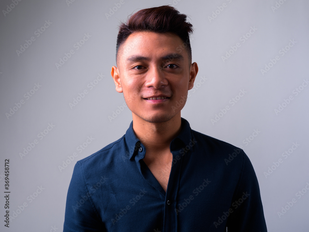 Face of happy young Asian businessman smiling Face of happy young Asian businessman smiling