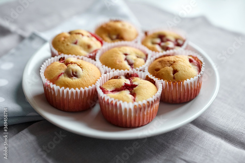 Homemade strawberry muffins on white plate over linen napkin