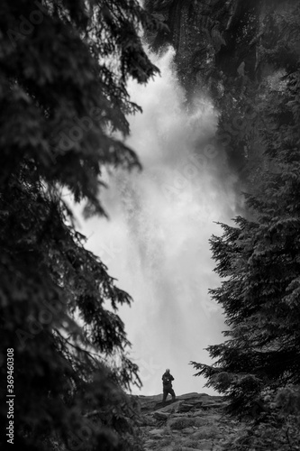 silhouette of a man standing on a rock under the waterfall in Krimml in Austrian Alps