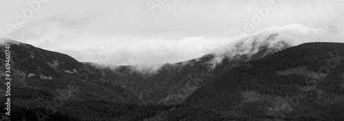 Panoramatic shot of the Sněžka mountain in the clouds on a cloudy day