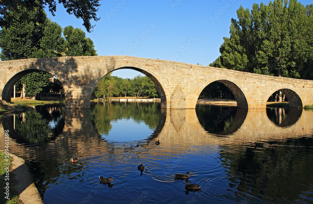 Old arched bridge over river, Spain