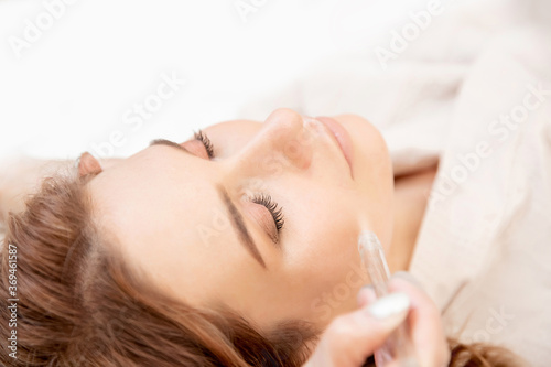 Procedure wet cleaning skin of face from blackheads, acne of young woman in clinic