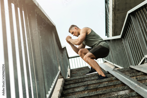 Muscular man during workout on a stairscase photo