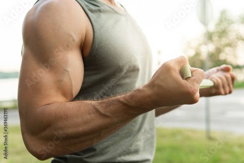 Man during  workout with a resistance rubber bands outdoors.