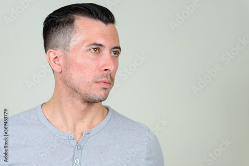 Portrait of young handsome man thinking and looking up