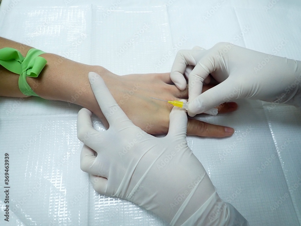 Stockfoto Close up,Hand of nurse is inserting iv catheter or needle