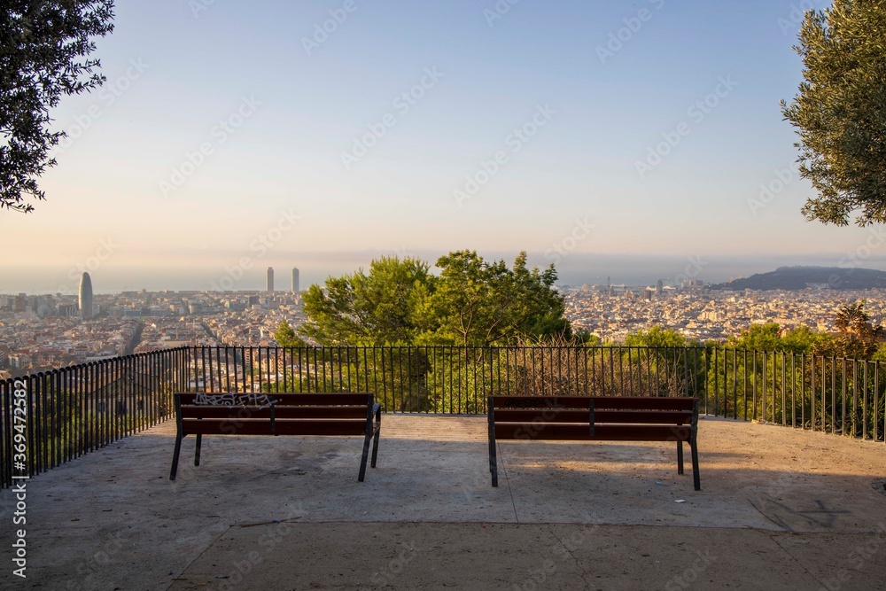 bench in the park with the city of Barcelona in the background