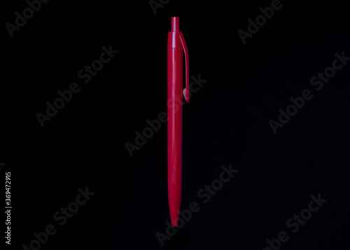 Red pen on black background. Copy space, isolated.