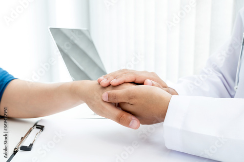 The female doctor uses a friendly hand to hold the patient s hand to give confidence and show care about health care. Medical concepts and good health