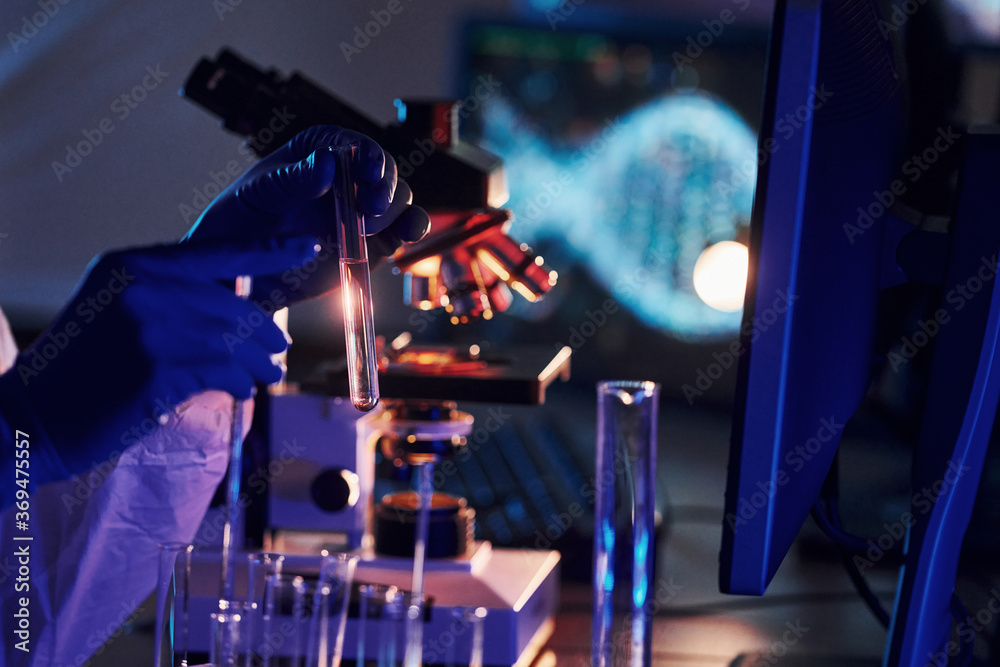 Scientist in white protective uniform works with coronavirus and blood tubes in laboratory Scientist in white protective uniform works with coronavirus and blood tubes in laboratory