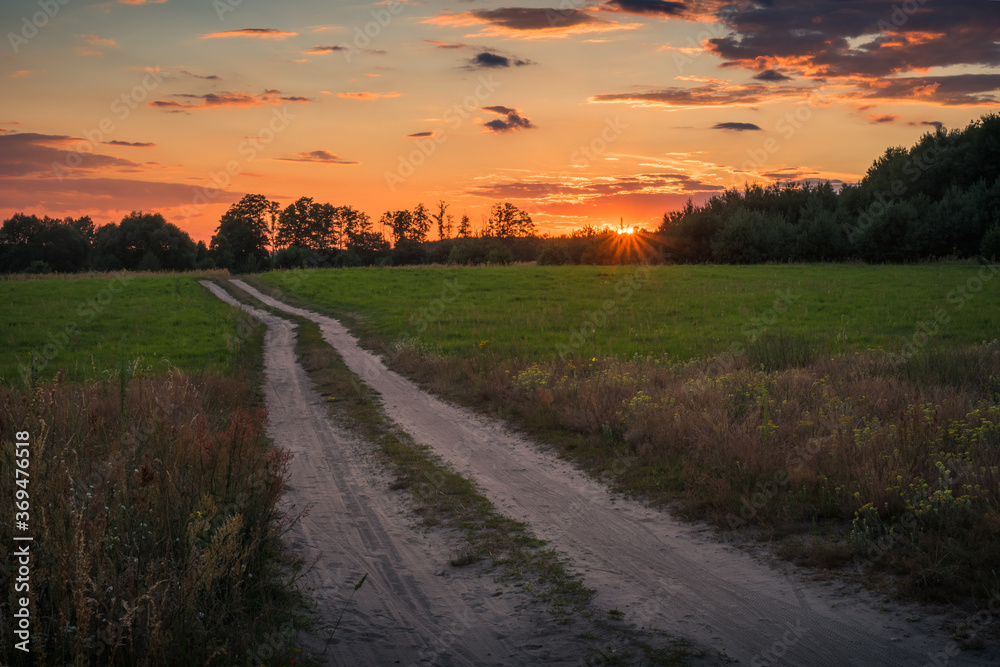 Sunset over the gravel road in the Liwiec river valley near Siedlce, Masovia, Poland